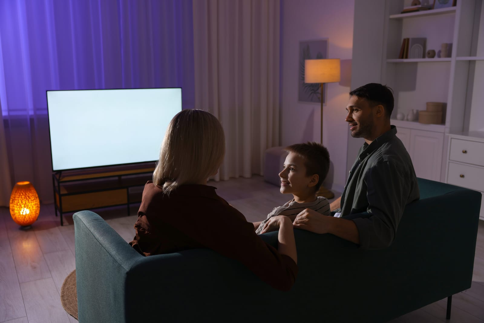 A family sitting together watching television at home in the evening