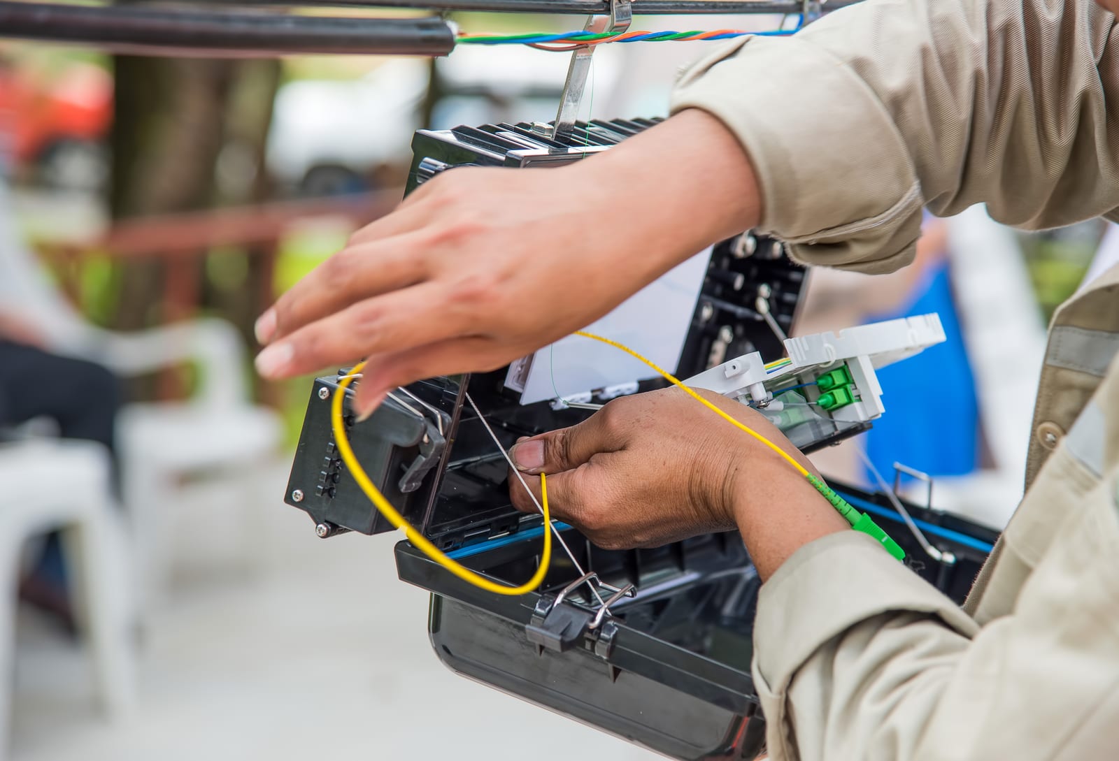 A technician joining fibre optic strands inside a street cabinet