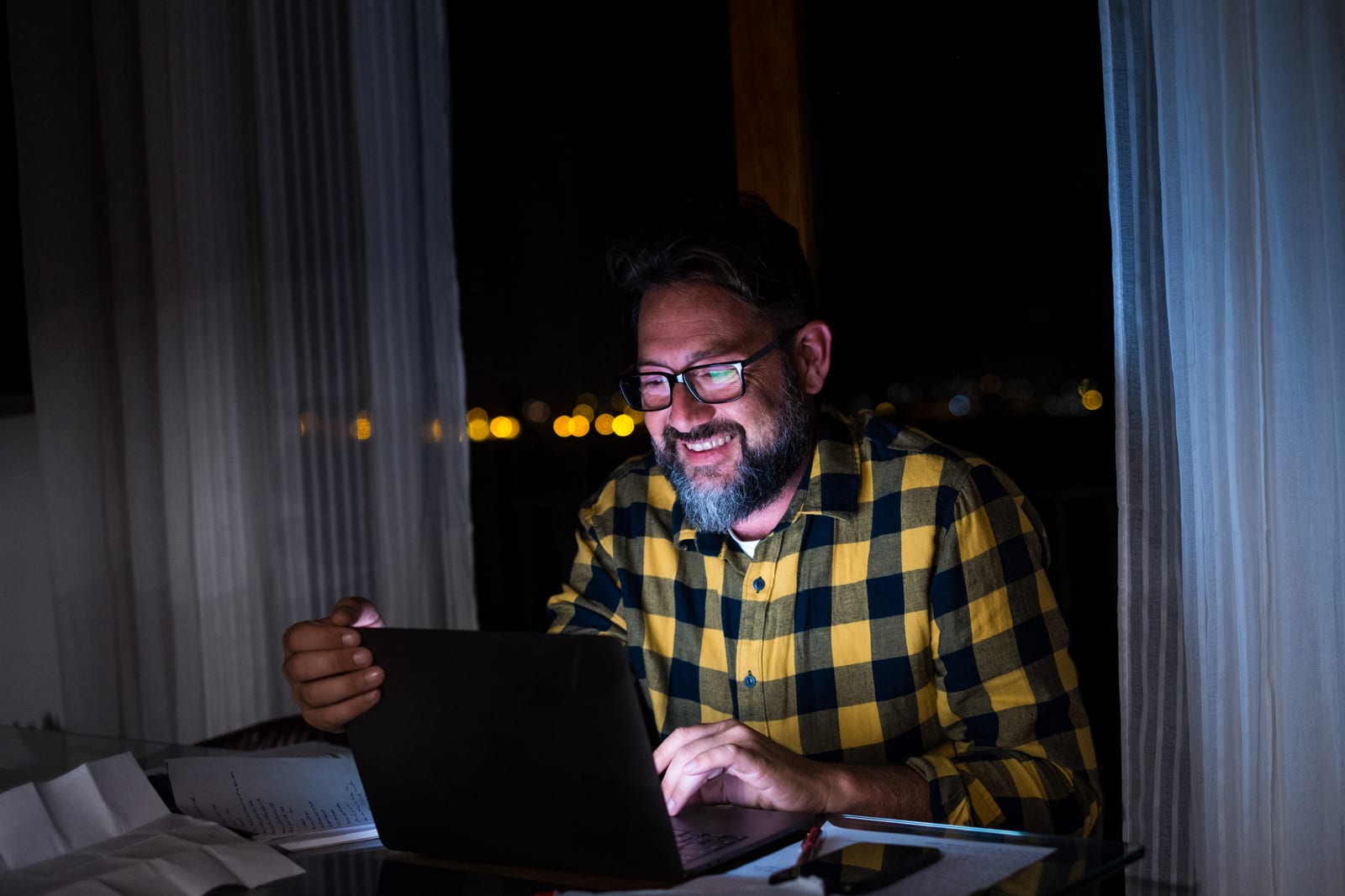 A man working on a laptop late at night at home